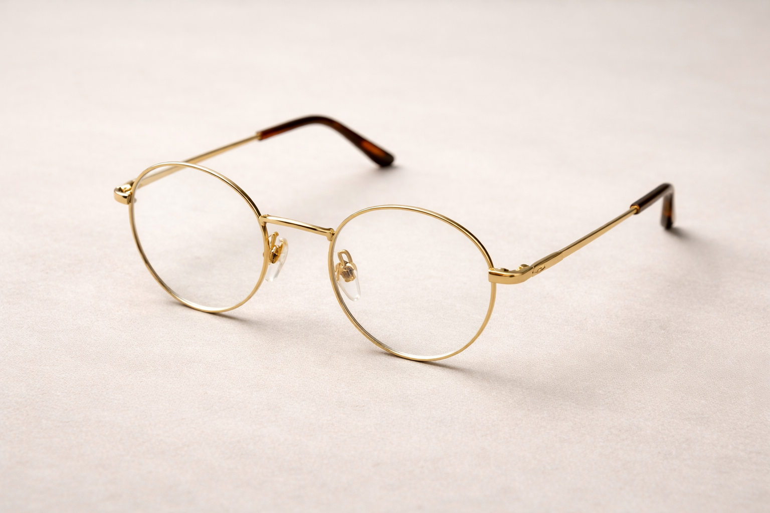 Elegant gold-rimmed glasses on beige surface Classic Gold-Rim Eyeglasses - Image 1